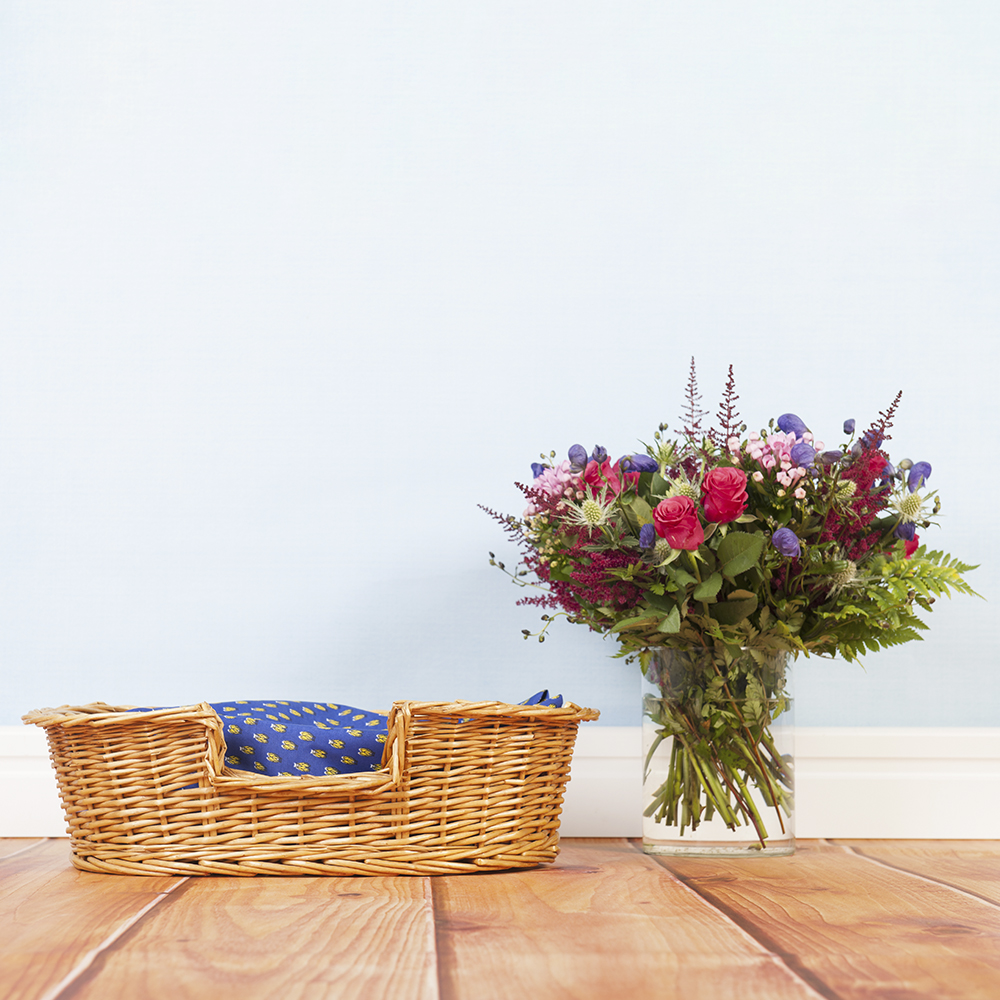 A photograph of a dog bed and flowers